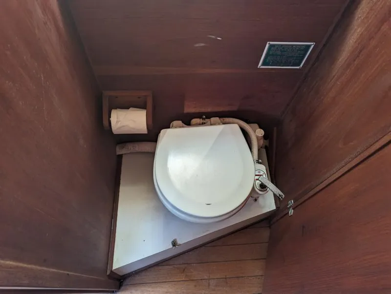 Slide: The Image of 1979 Sabre 28-2 boat toilet with wooden enclosure and toilet paper holder. - 30
