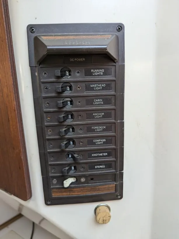 Slide: The Image of Electrical panel on a 1979 Sabre 28-2 sailboat with labeled switches for various lights and devices. - 38