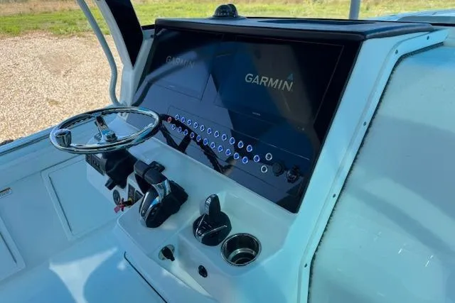 Slide: The Image of 2023 Edgewater 370CC boat dashboard with Garmin navigation system and steering wheel. - 10