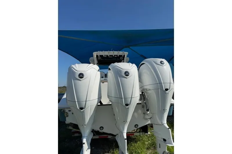 Slide: The Image of 2023 Edgewater 370CC boat with triple outboard engines under a blue canopy. - 18