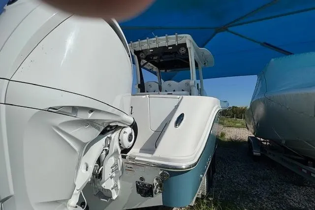 Slide: The Image of 2023 Edgewater 370CC boat under blue canopy, rear view with outboard motor. - 19