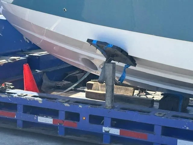 Slide: The Image of 2023 Edgewater 370 boat on trailer, secured with blue straps, near orange cone. - 4