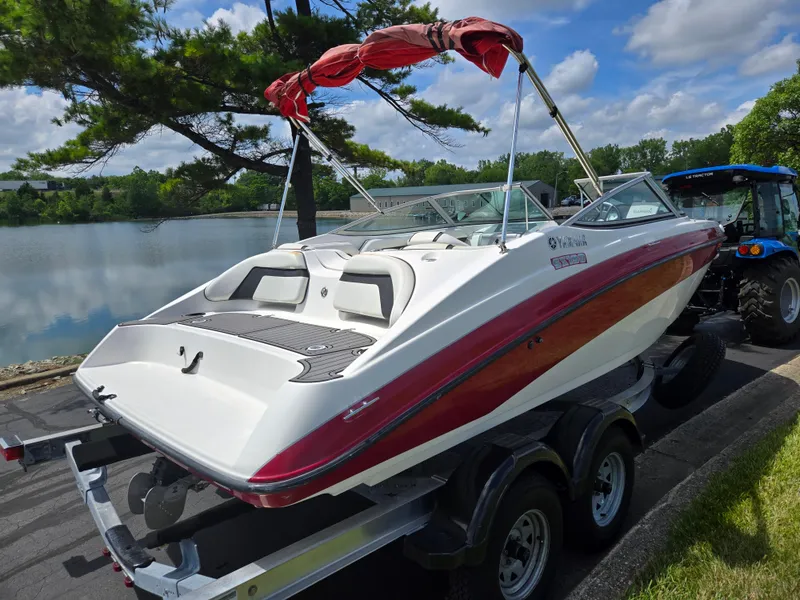 Slide: The Image of 2015 Yamaha SX190 boat on trailer by a lake, under a partly cloudy sky. - 1