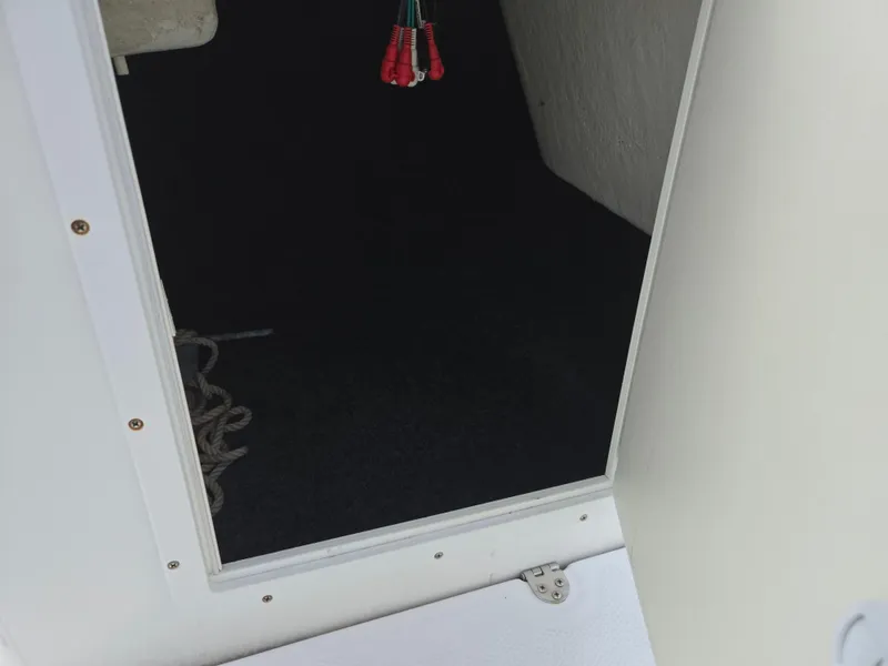 Slide: The Image of Open storage compartment on a 2015 Yamaha SX190 boat, showing interior and rope. - 16