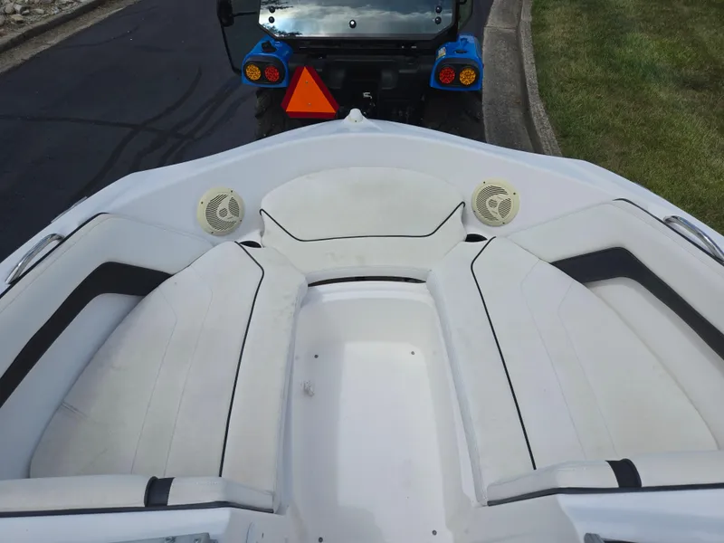 Slide: The Image of 2015 Yamaha Boats SX190 interior with white seating and speakers, parked on a street. - 18