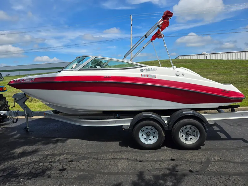 Slide: The Image of 2015 Yamaha Boats SX190 on trailer, red and white design, parked outdoors. - 4