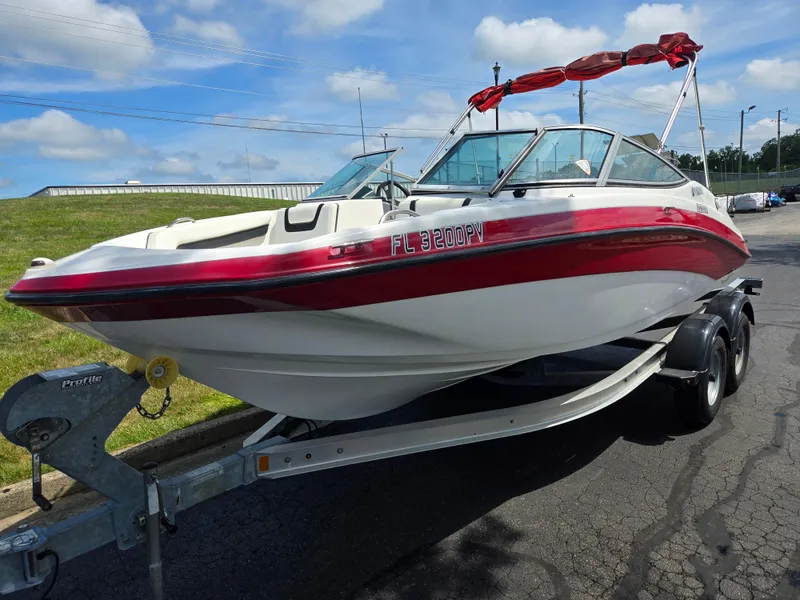 Slide: The Image of 2015 Yamaha Boats SX190 on trailer, red and white design, parked outdoors. - 5
