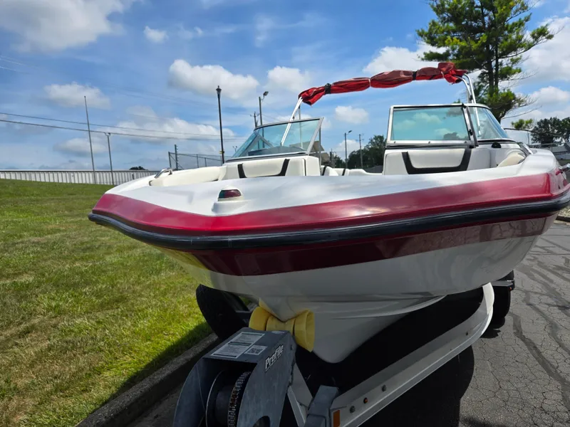 Slide: The Image of 2015 Yamaha SX190 boat with red accents on a trailer, parked outdoors. - 6