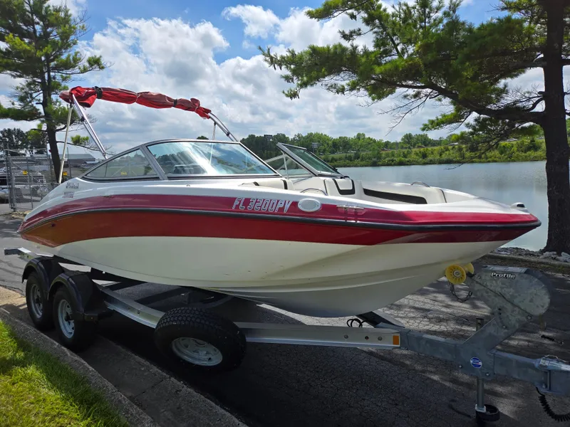 Slide: The Image of 2015 Yamaha SX190 boat on trailer by a lake, under a partly cloudy sky. - 8