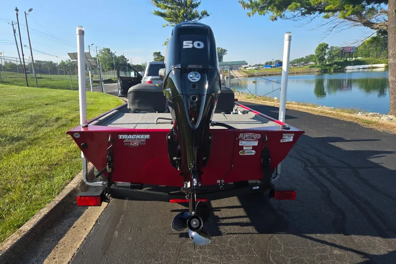 Slide: The Image of 2023 Tracker Bass Tracker Classic XL boat with 50 HP engine, parked near a lake. - 2