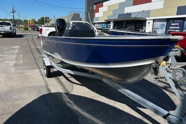 Slide: The Image of 2026 Lund 1600 Fury SS boat on trailer, parked outdoors near a building. - 1
