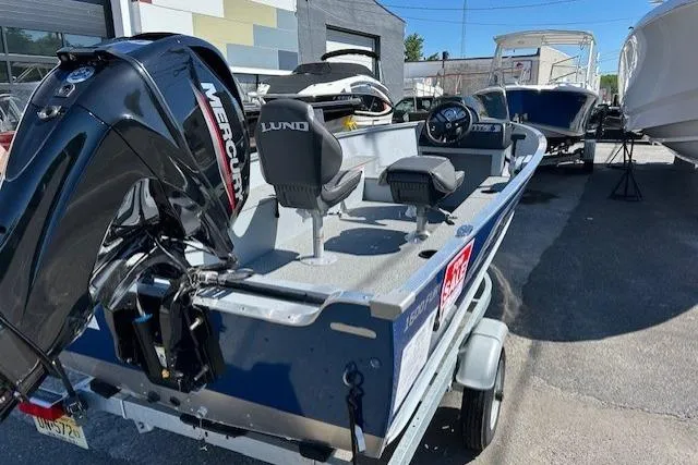 Slide: The Image of 2026 Lund 1600 Fury SS boat with Mercury engine, parked on a trailer in a marina. - 5