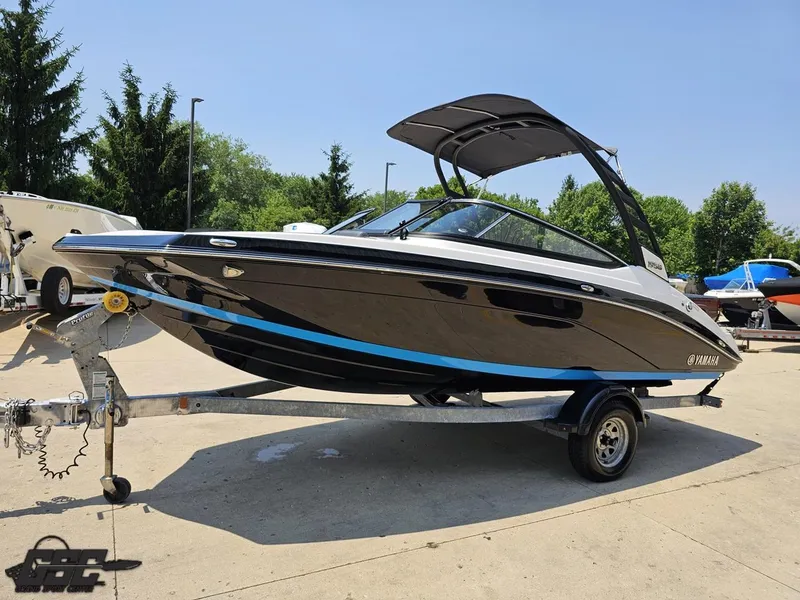 Slide: The Image of 2022 Yamaha Boats 195S on trailer, sleek black design, parked outdoors. - 15
