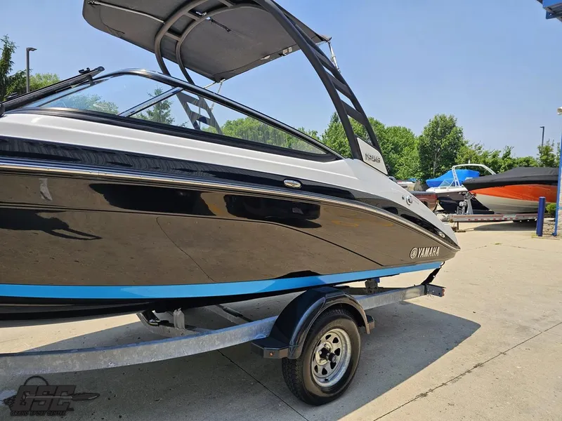 Slide: The Image of 2022 Yamaha Boats 195S on trailer, sleek black and white design, sunny day. - 17
