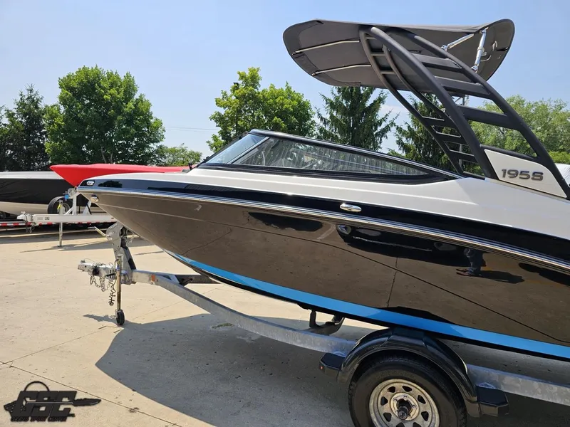 Slide: The Image of 2022 Yamaha Boats 195S on trailer, sleek design, black and blue accents, outdoor setting. - 19