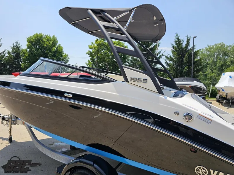 Slide: The Image of 2022 Yamaha Boats 195S on trailer, sleek design, black and white exterior, outdoor setting. - 21