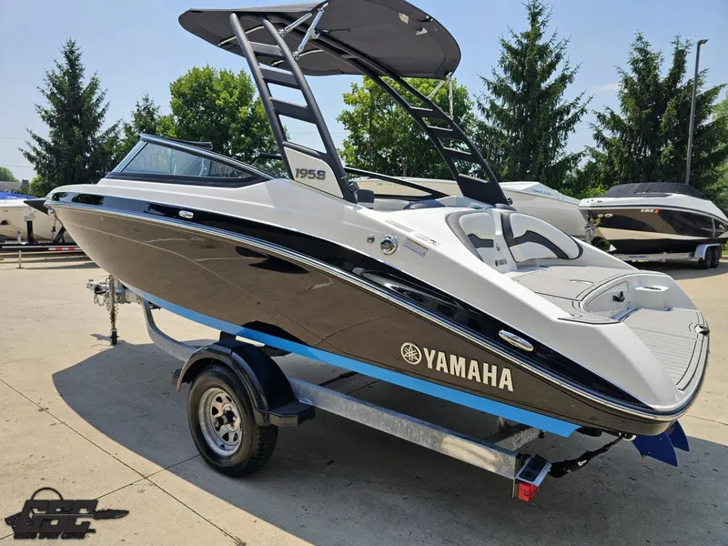 Slide: The Image of 2022 Yamaha Boats 195S on trailer, sleek design, black and white finish, outdoor setting. - 22