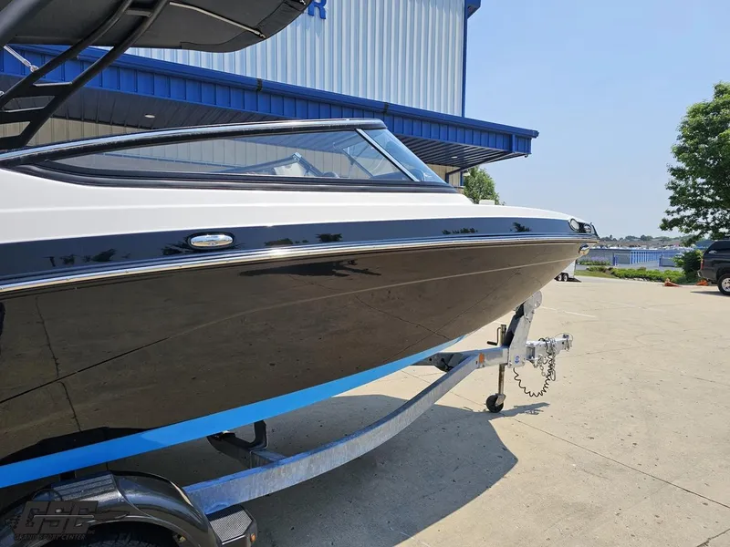 Slide: The Image of 2022 Yamaha Boats 195S on trailer, parked outdoors near a blue building. - 4