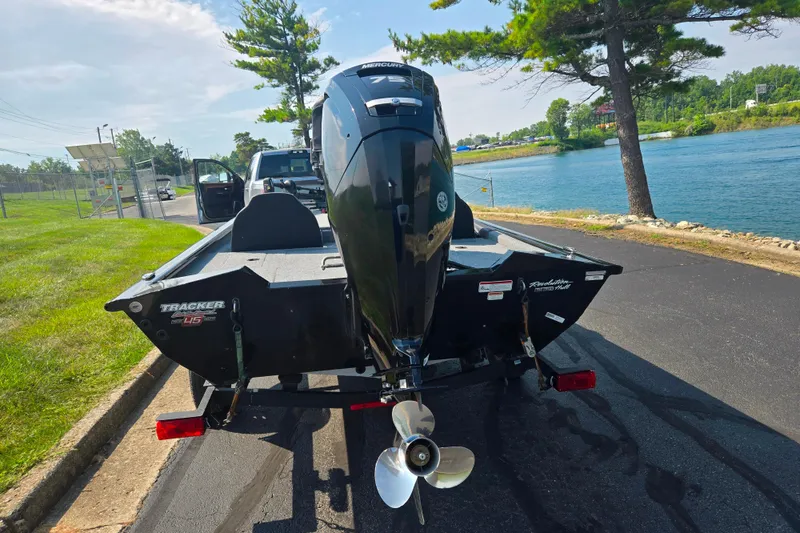 Slide: The Image of 2023 Tracker Pro Team 175 TXW boat on trailer by a lakeside road. - 2