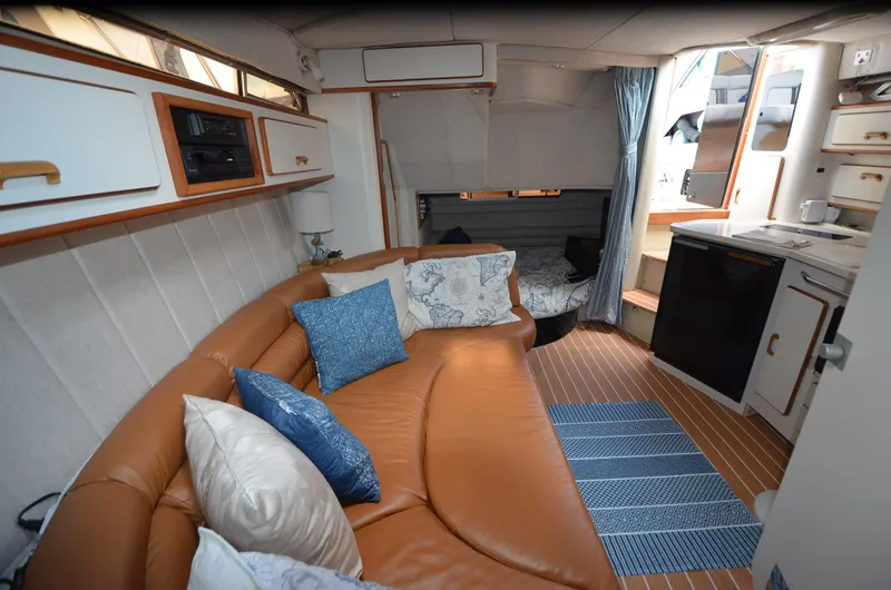 Slide: The Image of Interior of 1990 Sea Ray 350 Sundancer Coupe with leather seating and compact kitchen area. - 12