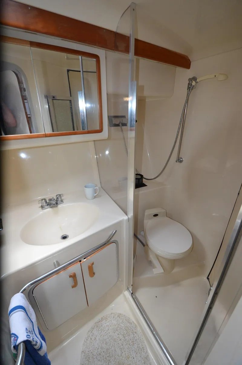 Slide: The Image of 1990 Sea Ray 350 Sundancer Coupe bathroom with shower, sink, and toilet. - 21