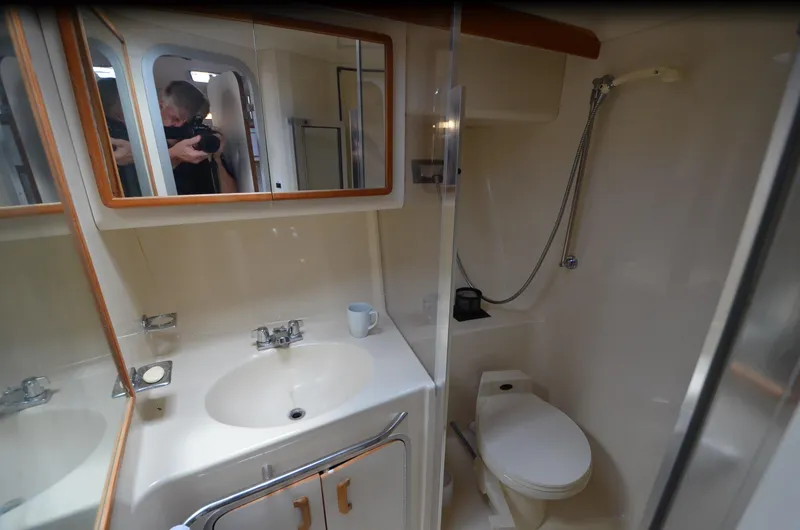 Slide: The Image of Bathroom interior of 1990 Sea Ray 350 Sundancer Coupe with sink, mirror, and toilet. - 22