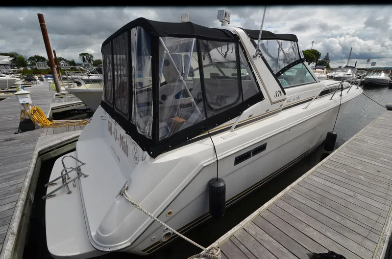 Slide: The Image of 1990 Sea Ray 350 Sundancer Coupe docked at marina under cloudy sky. - 4