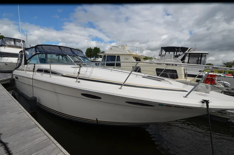 Slide: The Image of 1990 Sea Ray 350 Sundancer Coupe docked at marina under cloudy sky. - 5
