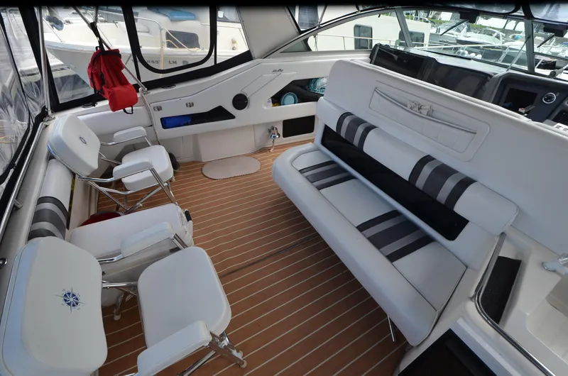 Slide: The Image of Interior of 1990 Sea Ray 350 Sundancer Coupe with white seating and wood flooring. - 6