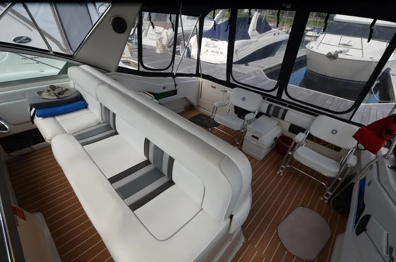Slide: The Image of Interior of 1990 Sea Ray 350 Sundancer Coupe with white seating and wood flooring. - 9