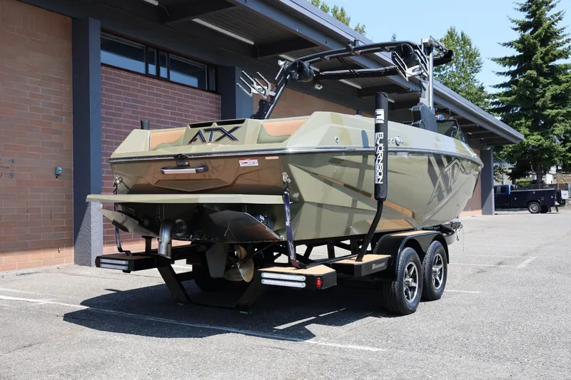 Slide: The Image of 2023 ATX Surf Boats 22 Type-S on trailer, parked outdoors near a brick building. - 15