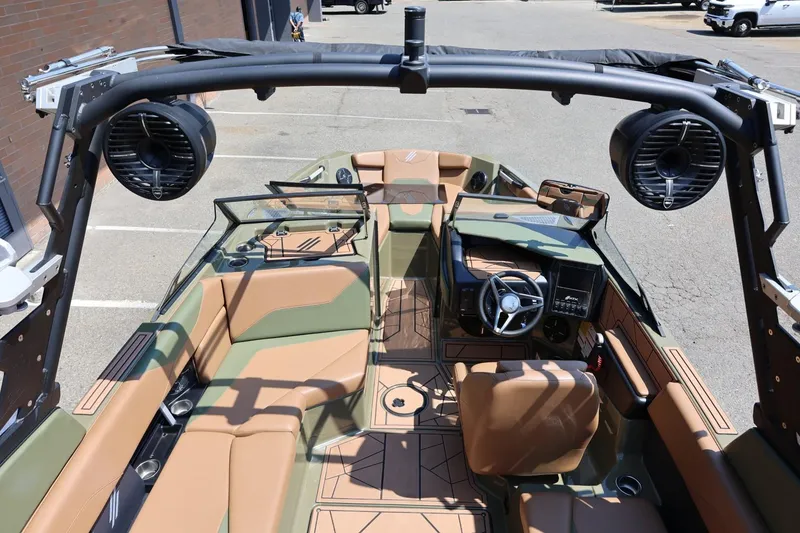 Slide: The Image of 2023 ATX Surf Boats 22 Type-S interior with tan and green seating, steering wheel, and speakers. - 24