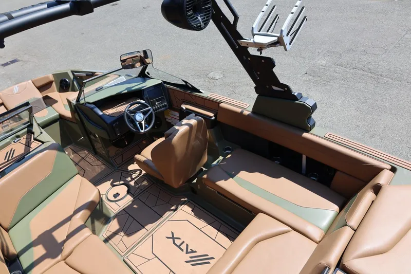 Slide: The Image of 2023 ATX Surf Boats 22 Type-S interior with tan and green seating, modern dashboard, and steering wheel. - 26
