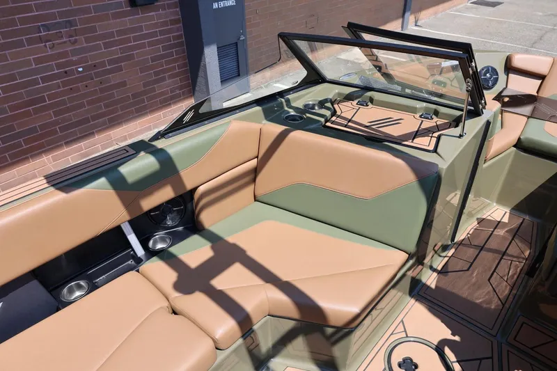 Slide: The Image of 2023 ATX Surf Boats 22 Type-S interior with tan and green seating, cup holders, and speakers. - 27