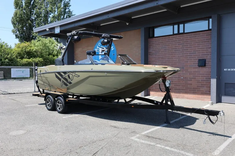 Slide: The Image of 2023 ATX Surf Boats 22 Type-S on trailer, parked outdoors near a brick building. - 3