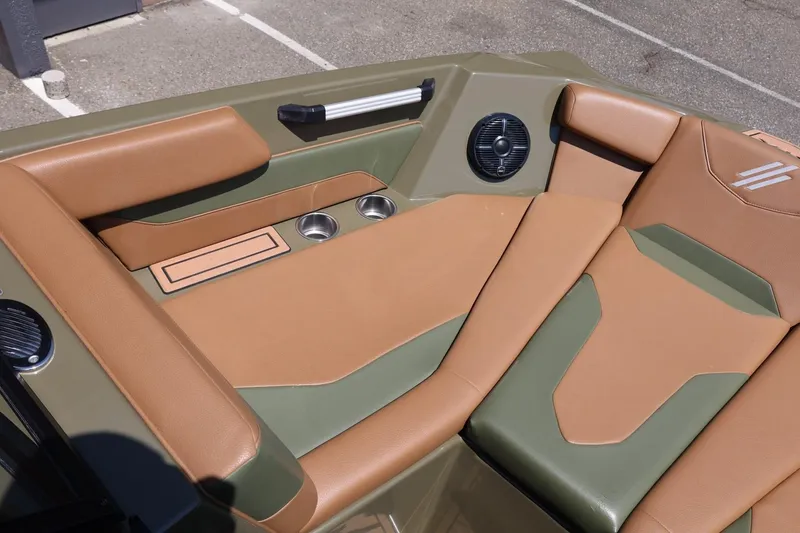 Slide: The Image of 2023 ATX Surf Boats 22 Type-S interior with tan and green seating, cup holders, and speaker. - 42