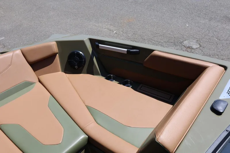 Slide: The Image of 2023 ATX Surf Boats 22 Type-S interior with tan and green seating, cup holders, and speaker. - 43