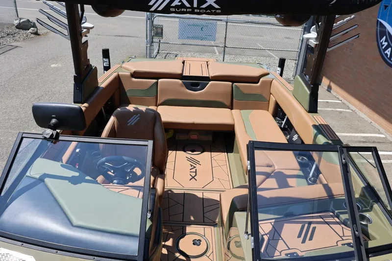 Slide: The Image of 2023 ATX Surf Boats 22 Type-S interior with tan and green seating, open windshield, and modern design. - 44