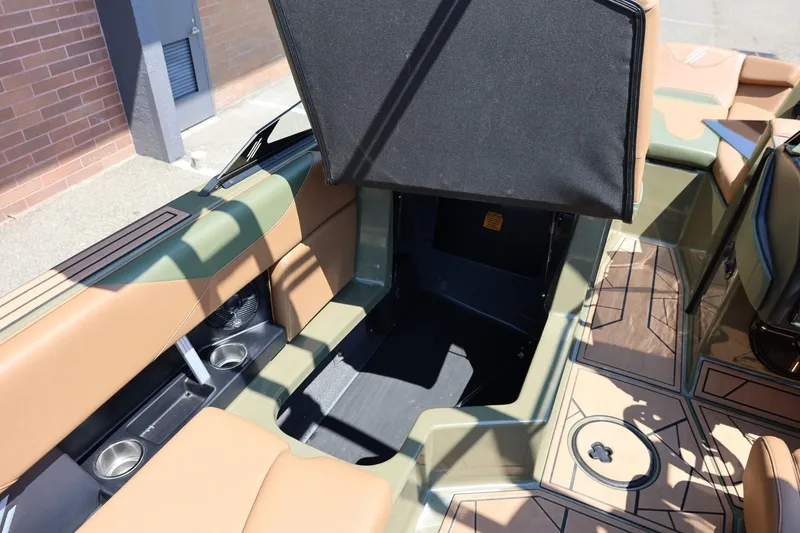 Slide: The Image of 2023 ATX Surf Boats 22 Type-S interior with open storage compartment, tan and green seating. - 46