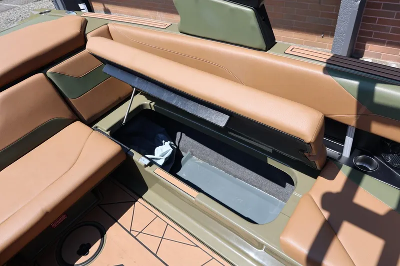 Slide: The Image of 2023 ATX Surf Boats 22 Type-S interior storage compartment with tan and green seating. - 47