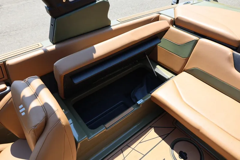 Slide: The Image of 2023 ATX Surf Boats 22 Type-S interior with tan and green seating, open storage compartment. - 48