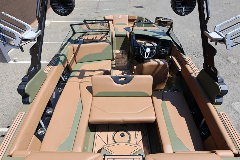 Slide: The Image of 2023 ATX Surf Boats 22 Type-S interior with tan and green seating, modern dashboard, and speakers. - 49
