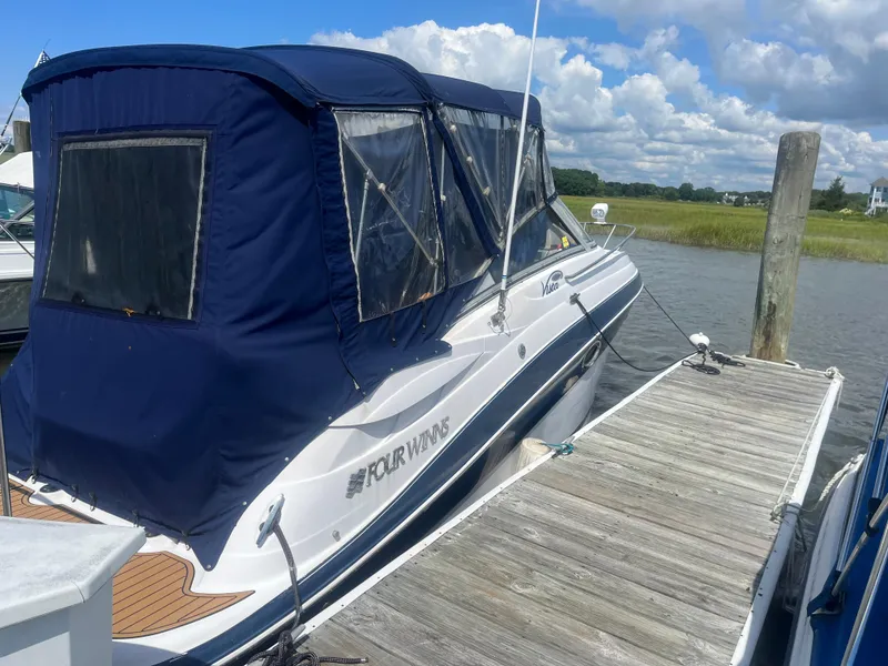 The Image of 2007 Four Winns 258 Vista boat docked with blue canopy under cloudy sky. - 0