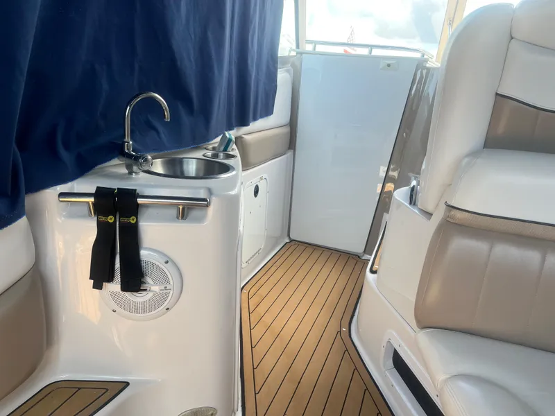 Slide: The Image of 2007 Four Winns 258 Vista boat interior with sink, seating, and wood flooring. - 11