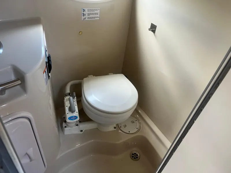 Slide: The Image of 2007 Four Winns 258 Vista boat bathroom with compact toilet and sink. - 13