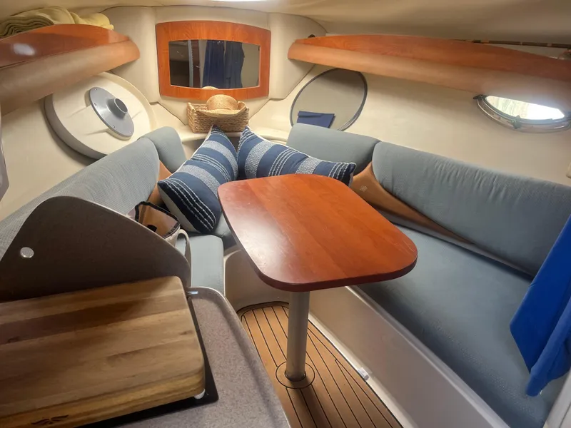 Slide: The Image of 2007 Four Winns 258 Vista cabin interior with cozy seating and wooden table. - 4