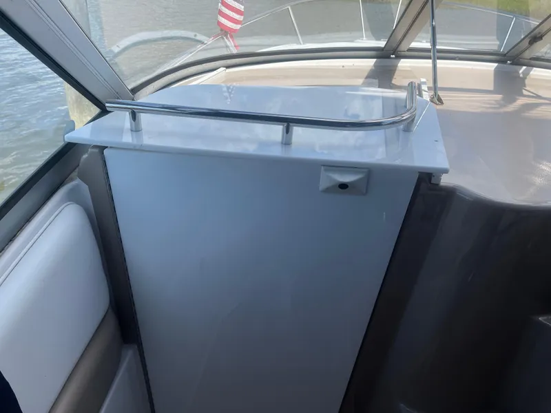 Slide: The Image of 2007 Four Winns 258 Vista boat interior with seating and railing, featuring a partial view of the water. - 7