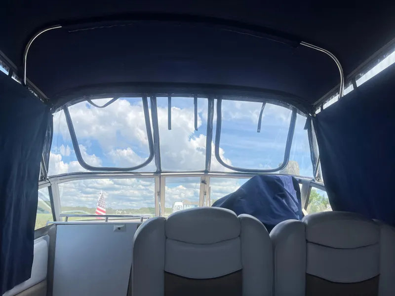 Slide: The Image of Interior view of 2007 Four Winns 258 Vista boat with blue canopy and scenic sky. - 9
