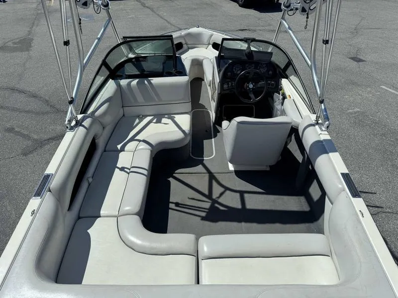 Slide: The Image of 1999 Malibu Sunsetter VLX boat interior with white seating and steering console. - 10