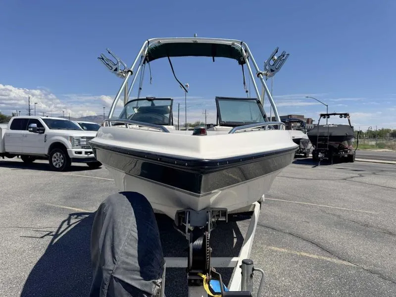 Slide: The Image of 1999 Malibu Sunsetter VLX boat on trailer in parking lot, clear sky background. - 4